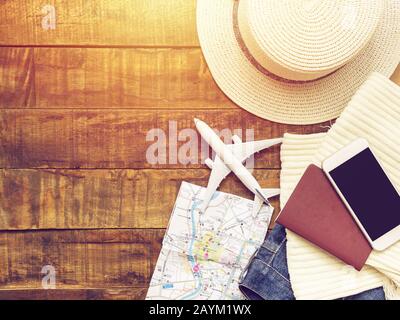 posa piatta di passaporto , modello piano bianco , mappa e accessori del viaggiatore su sfondo di legno con spazio copia. concetto di viaggio e vacanza Foto Stock