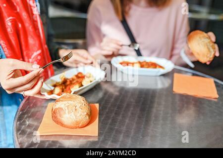 Donna Che Mangia Currywurst con il pane nel caffè Street food di Berlino. Cucina tedesca locale Foto Stock