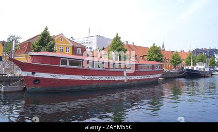 Copenhagen, DANIMARCA - 06th LUGLIO 2015: Casa galleggiante rossa sul canale della città. Barca wodden House ormeggiata in un canale Foto Stock