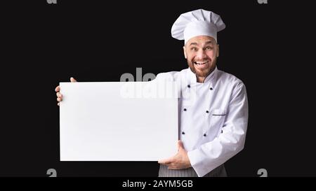 Allegro Maschio Chef Tenendo Vuoto White Poster Su Sfondo Nero Foto Stock