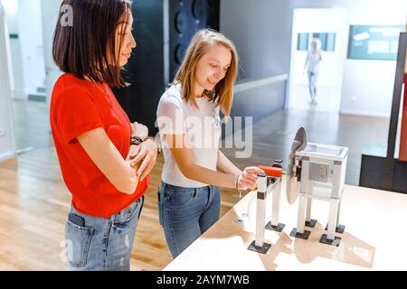 Donne studenti che fanno lavoro sperimentale nel campo della meccanica e della fisica in moderno laboratorio Foto Stock