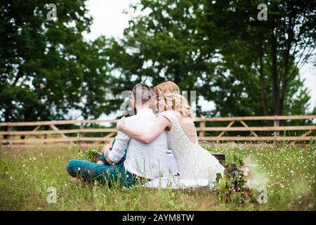 bella sposa e sposo hippster sono seduti sulla natura, stile rustico. Foto Stock