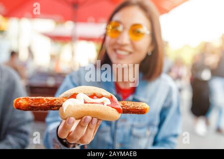 Donna che mangia Currywurst fast food salsiccia tedesca in bar all'aperto Street food Foto Stock