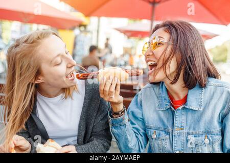 Donna che mangia Currywurst fast food salsiccia tedesca in bar all'aperto Street food Foto Stock