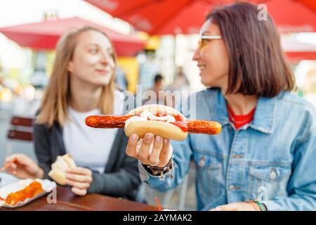 Donna che mangia Currywurst fast food salsiccia tedesca in bar all'aperto Street food Foto Stock