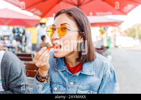 Donna che mangia Currywurst fast food salsiccia tedesca in bar all'aperto Street food Foto Stock