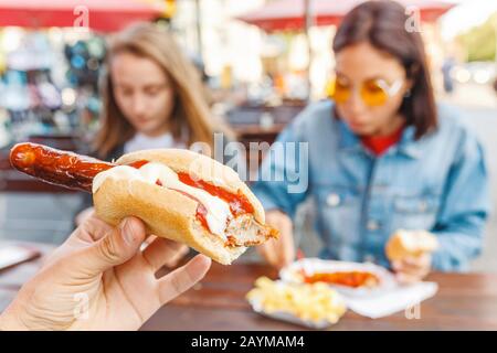 Donna che mangia Currywurst fast food salsiccia tedesca in bar all'aperto Street food Foto Stock