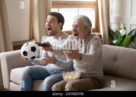 Due generazioni di appassionati di calcio a sostegno della squadra sportiva preferita. Foto Stock