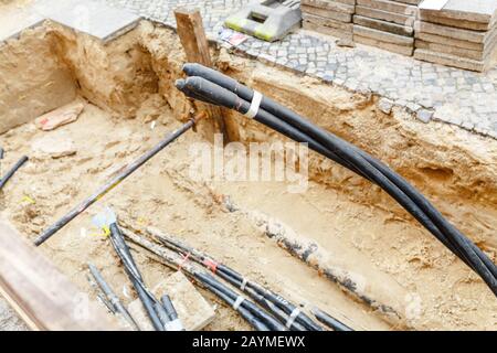 Cavi elettrici Installazione linee elettriche su strada, elettricità industriale e concetto di comunicazione Foto Stock