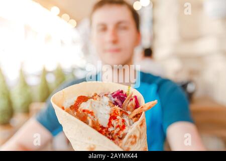 L'uomo che mangia Doner Kebap la sua cucina orientale media fast food Foto Stock