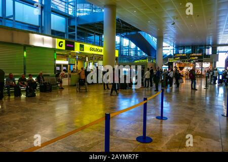 Noleggio auto Goldcar presso l'aeroporto di Alicante con coda di turisti Foto Stock