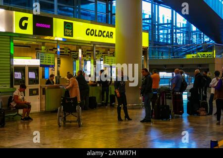 Noleggio auto Goldcar presso l'aeroporto di Alicante con coda di turisti Foto Stock