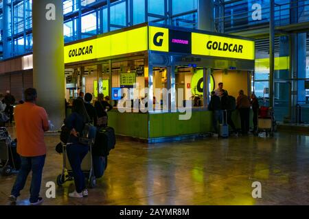 Noleggio auto Goldcar presso l'aeroporto di Alicante con coda di turisti Foto Stock