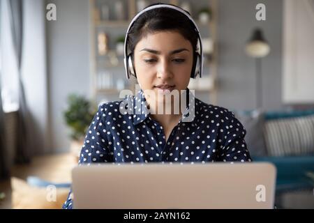 Millennial ragazza indiana in cuffie studio sul laptop Foto Stock