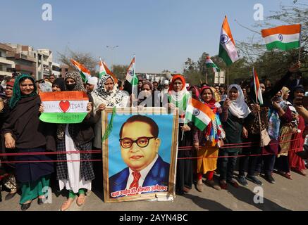 Le donne hanno un ritratto del dottor Bhimrao Ramji Ambedkar mentre sventolano le bandiere durante la protesta contro il nuovo atto di modifica di cittadinanza 2019 a Shaheen Bagh a Nuova Delhi. Foto Stock