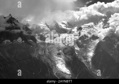 Una funivia scende da le Brevent a Plan Praz di fronte a una montagna coperta dal ghiacciaio Foto Stock