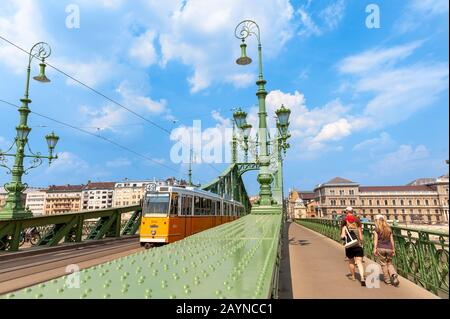 Tram che attraversa il Szabadság híd o il Ponte della libertà, Budapest, Ungheria Foto Stock