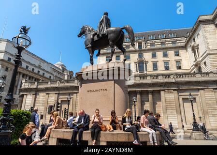 Gli impiegati che hanno la loro pausa pranzo fuori della Banca d'Inghilterra, Londra, Regno Unito Foto Stock