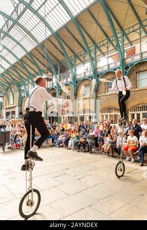 Juggling unicycle performer a Covent Garden, Londra, Regno Unito Foto Stock