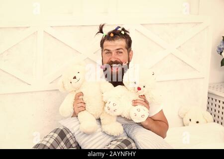 Uomo Barbuto giocare con orso giocattolo. Felice papà rilassanti camere da letto. padre con divertenti acconciatura. freaky hipster relax nel letto. rimanere a letto tutto il giorno. Il tempo di rilassarsi a casa. Felice paternità. ispirato al gioco. Foto Stock