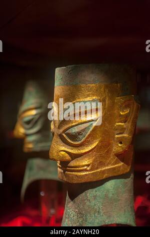 Una testa umana in bronzo con maschera d'oro del 12th secolo a.C. nella mostra di antichi manufatti al Museo Sanxingdui di Sanxingdui vicino a Chengdu, S. Foto Stock