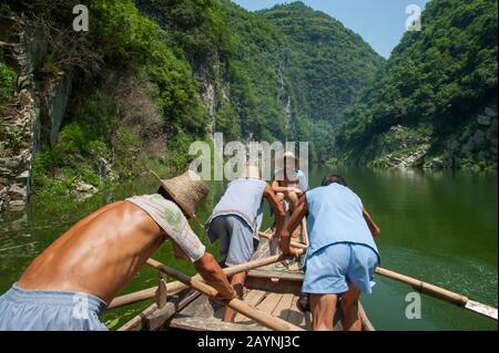 Uomini cinesi canottaggio una barca tradizionale Sampan vicino Badong sul torrente Shennong, un affluente del fiume Yangtze alla Gola di Wu (Tre Gole) in CH Foto Stock