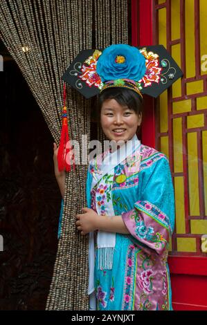 Una cameriera vestita con un costume storico al ristorante Bai Jia da Yuan di Pechino, Cina. Foto Stock
