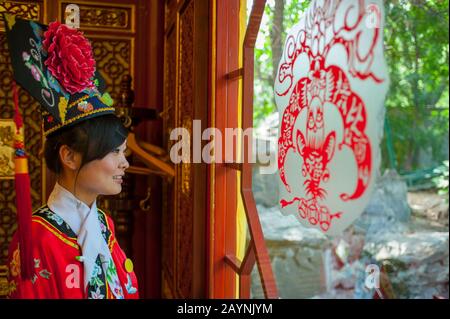Una cameriera vestita con un costume storico al ristorante Bai Jia da Yuan di Pechino, Cina. Foto Stock
