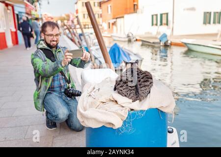 Uomo turistico scattare foto di un cappello vagante a venezia Foto Stock