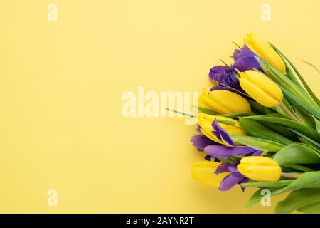 Tulipani Gialli E Iris Su Sfondo Giallo. Concetto Dell'8 Marzo Festa Della Donna, Festa Della Madre, Boquet Fiori Di Primavera Foto Stock