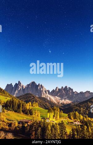 Valle Funes in montagna Dolomiti di notte. Stelle e chiaro di luna sulla catena montuosa di Odle Foto Stock