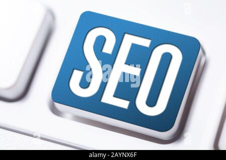 Pulsante Di Ottimizzazione Del Motore Di Ricerca Seo Blu Su Una Tastiera Bianca, Concetto Di Marketing Aziendale Foto Stock