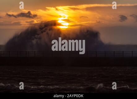 Heysham, Lancashire, Regno Unito. 16th Feb, 2020. High Tide e Sunset si combinano per produrre un'immagine mozzafiato dell'onda che si infrangono sul Grosvenor Breakwater davanti al sole che tramonta di Domenica Pomeriggio credito: Photographing North/Alamy Live News Foto Stock