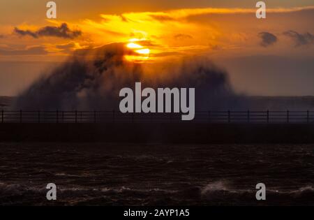 Heysham, Lancashire, Regno Unito. 16th Feb, 2020. High Tide e Sunset si combinano per produrre un'immagine mozzafiato dell'onda che si infrangono sul Grosvenor Breakwater davanti al sole che tramonta di Domenica Pomeriggio credito: Photographing North/Alamy Live News Foto Stock