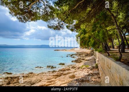 Costa di Bol, isola di Brac, Croazia. Vista panoramica con pini, montagne e acque turchesi del mare Adriatico in giornata di sole. Famoso destin turistico Foto Stock