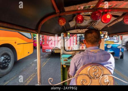 Autista tuk tuk nel centro di Bangkok nelle trafficate aree turistiche e nel traffico e nel traffico del centro città. Foto Stock