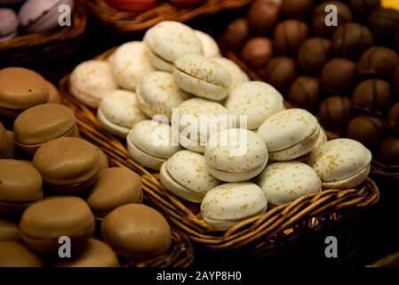 Freschi e colorati deliziosi macaron rotondi biscotti dolci con cioccolato su un piatto Foto Stock