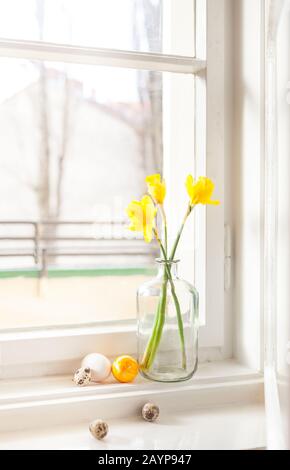 decorazione minimalistica di pasqua su campanelli di pasqua a daffodils in vecchio edificio uova di pasqua su davanzale sfondo chiaro, con spazio copia Foto Stock