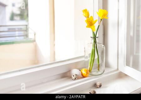 decorazione minimalistica di pasqua su campanelli di pasqua a daffodils in vecchio edificio uova di pasqua su davanzale sfondo chiaro, con spazio copia Foto Stock