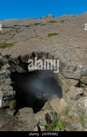 Vapore che sale da Grjotagja, una piccola grotta di lava vicino al lago Myvatn con una sorgente termale all'interno del nord-est dell'Islanda. Foto Stock