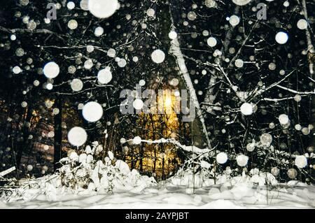 fiocchi di neve di notte. lanterna gialla al buio Foto Stock