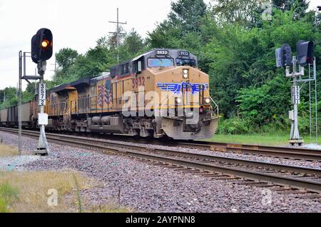 Elburn, Illinois, Stati Uniti. Locomotive dell'Unione del Pacifico che conducono un treno di tramogge di carbone vuote oltre un segnale di blocco. Foto Stock