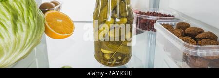 Shot panoramico di sottaceti con cotolette e frutta fresca sul ripiano frigo isolato su bianco, immagine stock Foto Stock