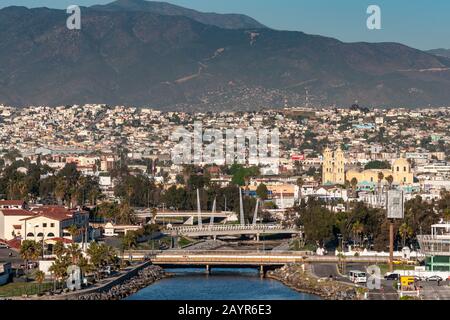 Ensenada, Messico - 17 gennaio 2012: Arroyo Ensenada si svuota nella baia e conduce alla Cattedrale gialla Di Nostra Signora di Guadalupe sotto il sole serale emersed i Foto Stock