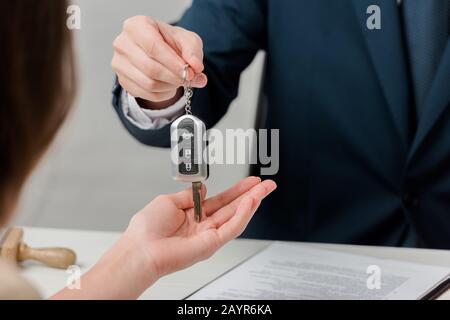 vista ritagliata del realtor che dà la chiave al cliente, concetto di leasing Foto Stock