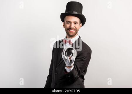 mago professionista che tiene palla magica, isolato su grigio Foto Stock