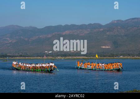 Una tradizionale corsa in barca a remi accompagnata da musica sul lago Inle in Myanmar con ogni barca che ha circa 70-80 rematori. Foto Stock