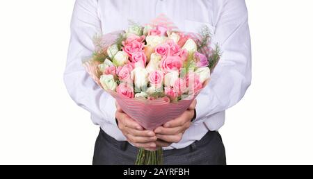 Un uomo in una camicia bianca tiene un bouquet di nozze nelle sue mani. Un grande bouquet di rose rosse, bianche e rosa per il giorno della madre, il giorno delle valentine, l'ingaggio Foto Stock