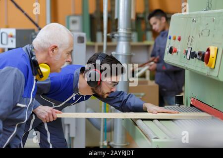 carpentieri che controllano la pianta del pavimento per il prossimo proyect Foto Stock