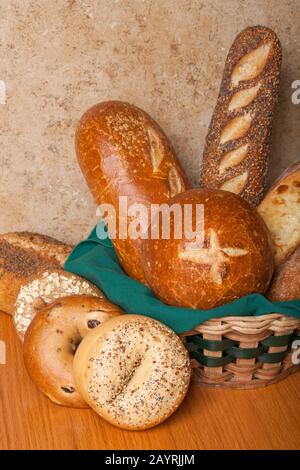Varietà di pane fatto in casa, con alcuni in un cestino di vimini con un tovagliolo di stoffa, compreso il vaso di pane di sourdough, pane di sourdough, tre pane di seme, tre Foto Stock